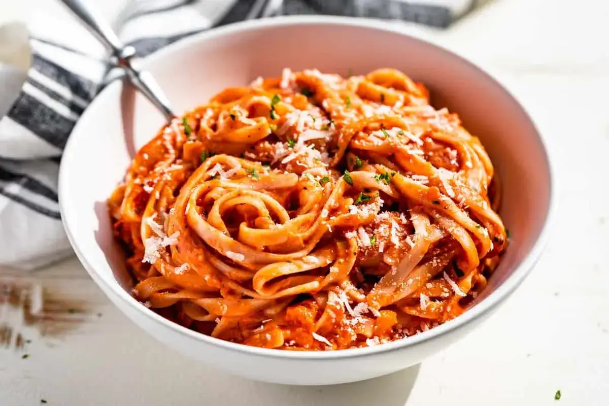 Pyszny makaron w kremowym sosie pomidorowym, posypany parmezanem i ziołami. Danie inspirowane przepisem makaron gigi hadid.