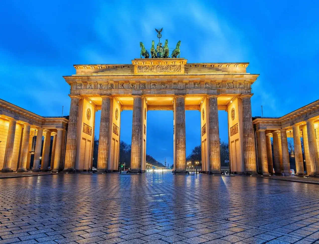 Brandenburger Tor bei Nacht, ein Muss für Fotospots in Berlin. Die Säulen leuchten im warmen Licht, der Himmel ist tiefblau.