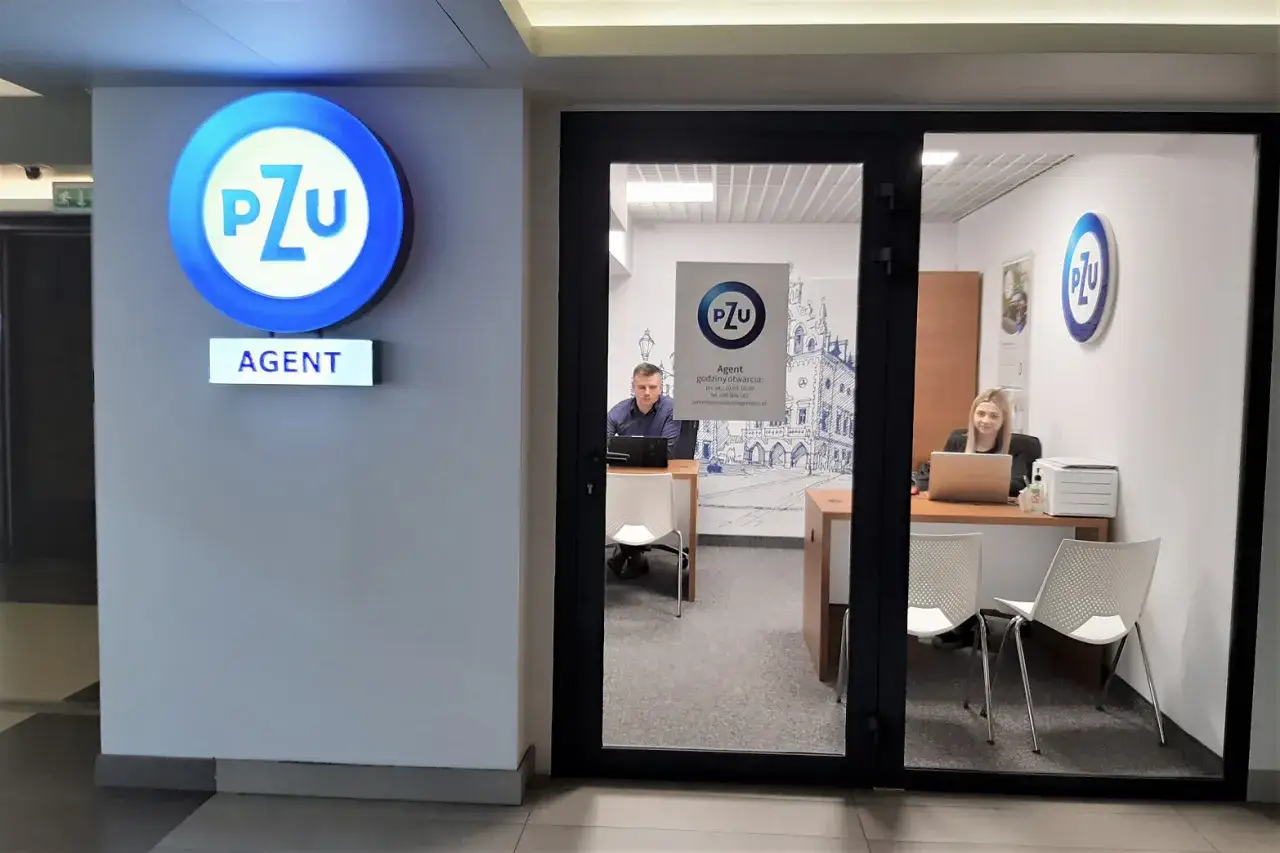 Biuro PZU z agentami przy biurkach, widoczne logo PZU i napis AGENT.