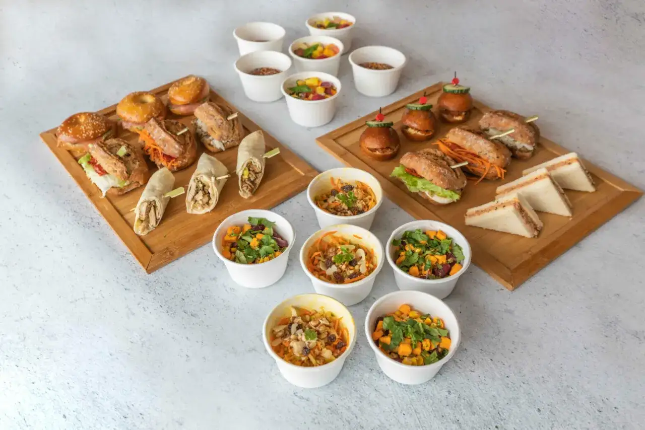 Un apéro dinatoire américain avec mini-burgers, wraps, sandwichs et salades en coupelles. Parfait pour un repas convivial et gourmand.
