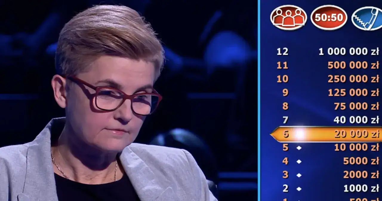 Kobieta w okularach na tle planszy z nagrodami w teleturnieju