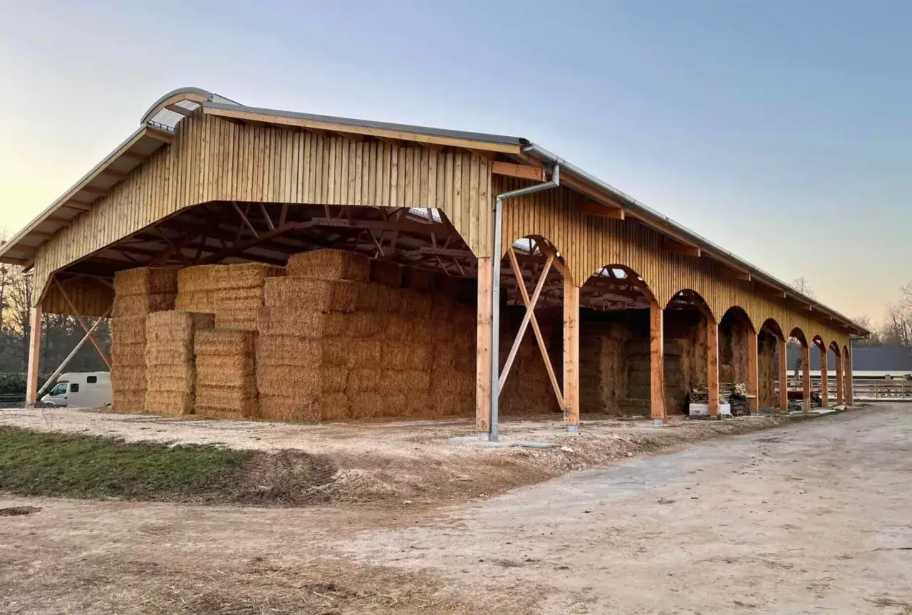 Grande grange en bois abritant un important stockage de foin, prêt pour l'hiver.
