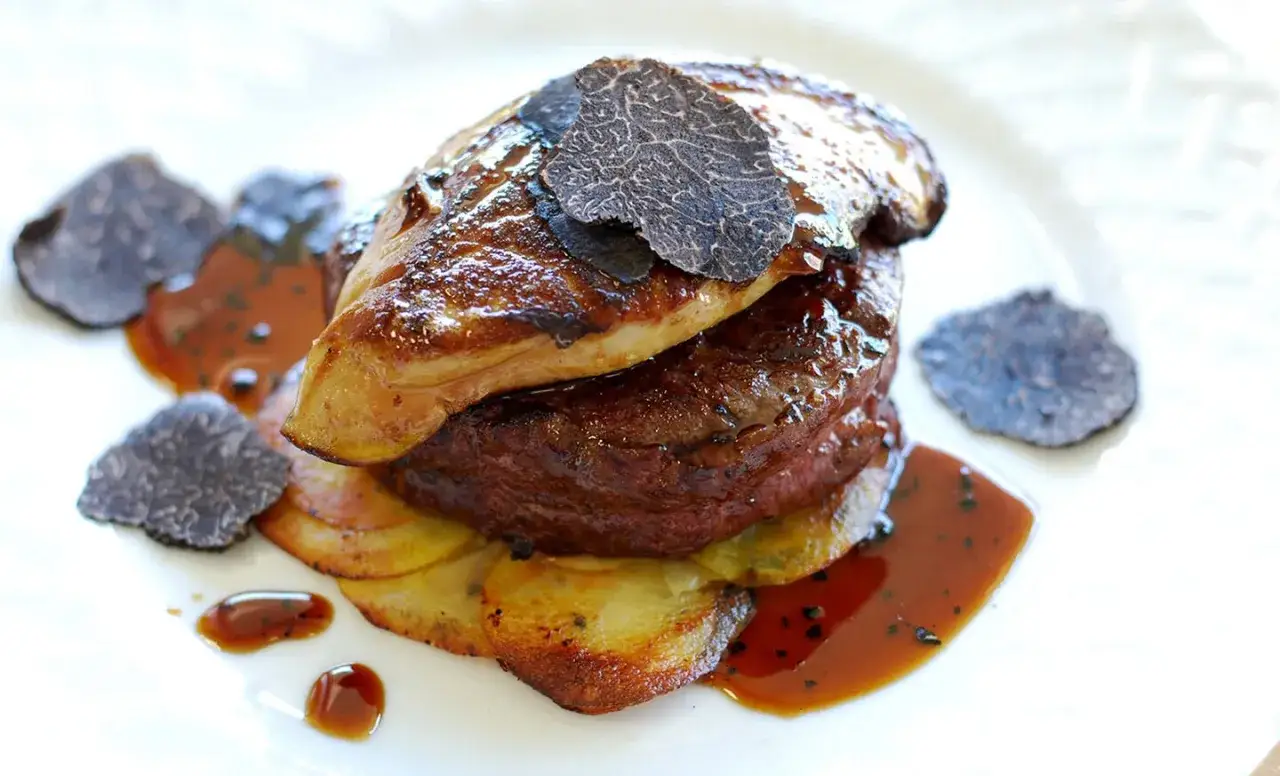 En lyxig tournedos Rossini med anklever, tryffel och potatis, serverad med en mustig s&aring;s.