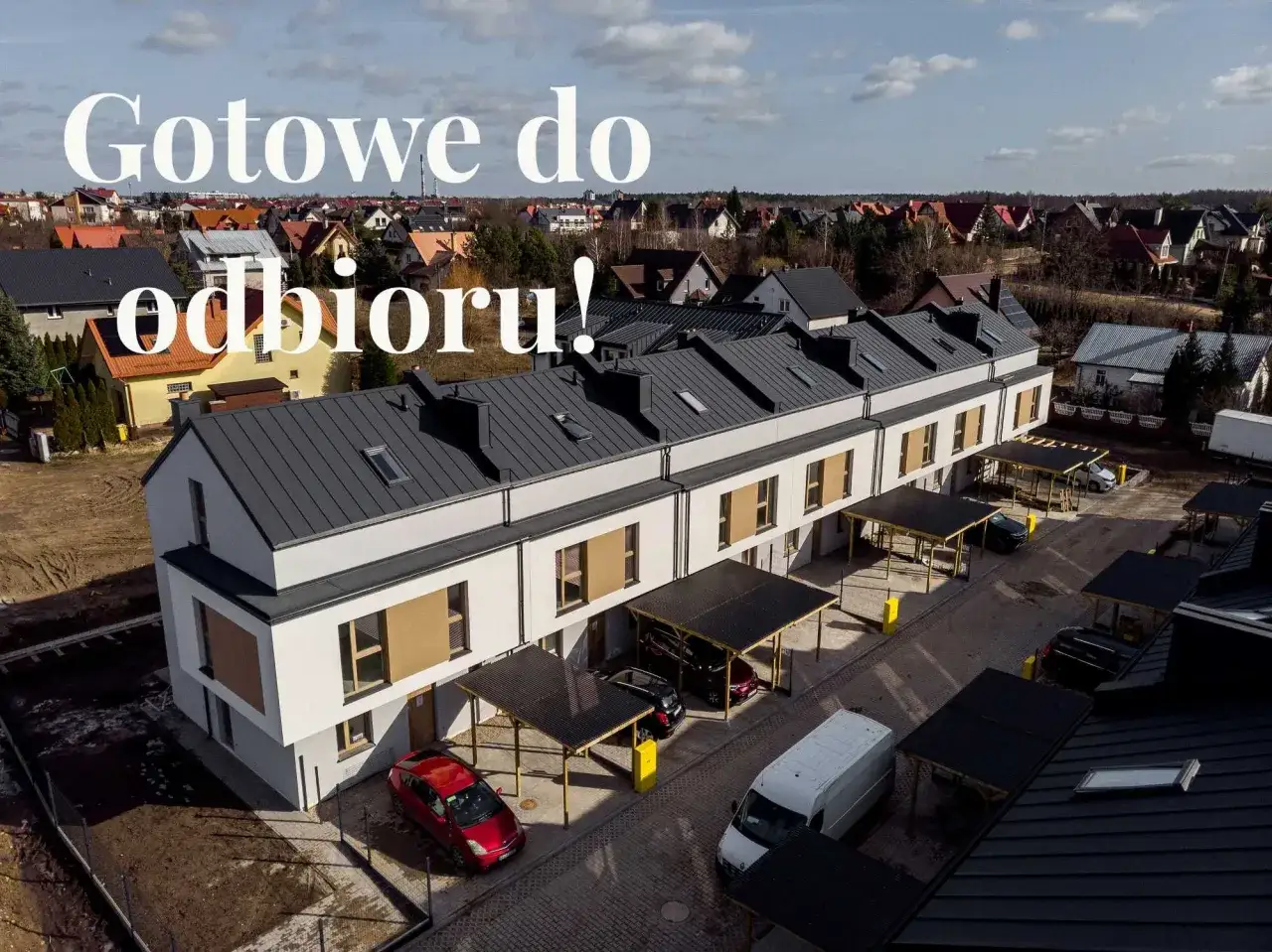 Nowe domy szeregowe z carportami i samochodami na podjeździe.
