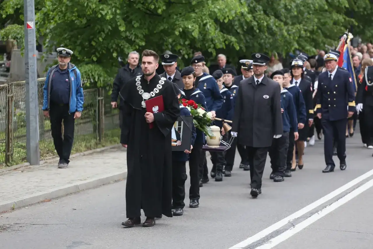 Mistrz ceremonii w todze prowadzi pogrzeb świecki. Różnica między pogrzebem świeckim a wyznaniowym jest widoczna w braku symboli religijnych.