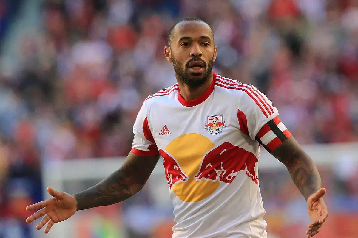Piłkarz MLS, Thierry Henry, w białej koszulce z czerwonymi pasami i logo Red Bull.