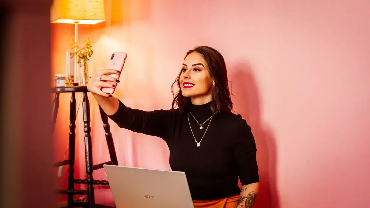 Kobieta robi selfie, zastanawiając się nad listą celebrytów, którzy stracili kontrakty reklamowe przez jeden wpis.