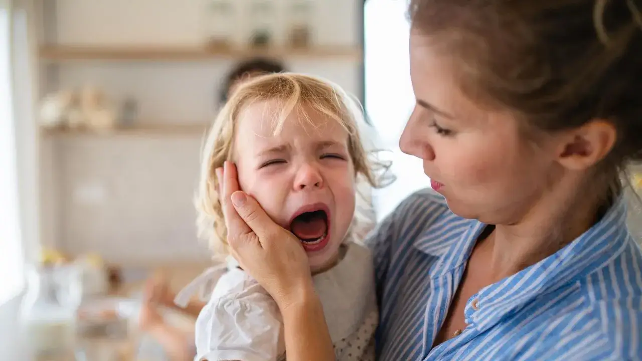 Madre consuela a su hijo de 2 años que llora desconsoladamente. Parece que mi hijo llora por todo, ¡qué etapa tan difícil!