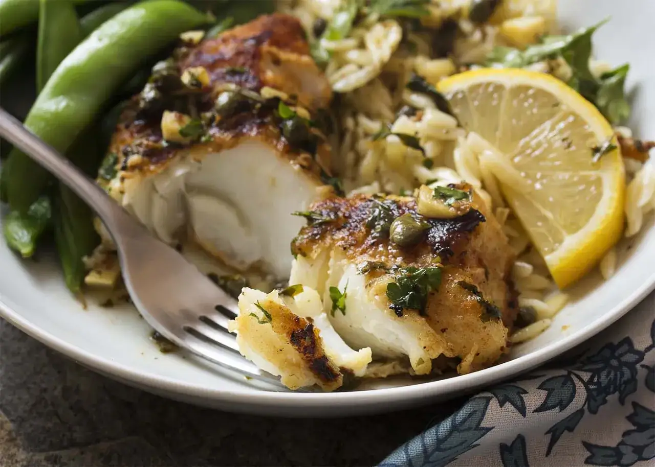 Morue grill&eacute;e savoureuse, servie avec des pois gourmands, du riz orzo et une tranche de citron. Un d&eacute;lice !