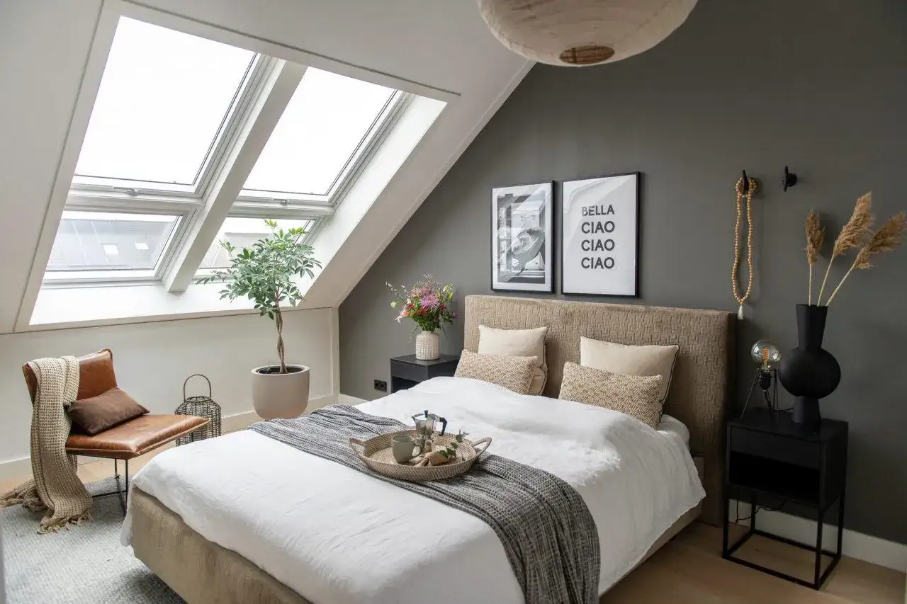 Camera da letto mansardata con letto accogliente, finestre sul tetto e un tocco di stile.