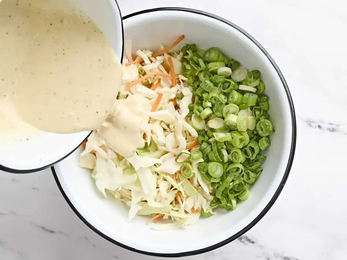 F&uuml;r das **Rezept Coleslaw Original** wird cremiges Dressing &uuml;ber fein geschnittenen Kohl, Karotten und Fr&uuml;hlingszwiebeln gegossen.