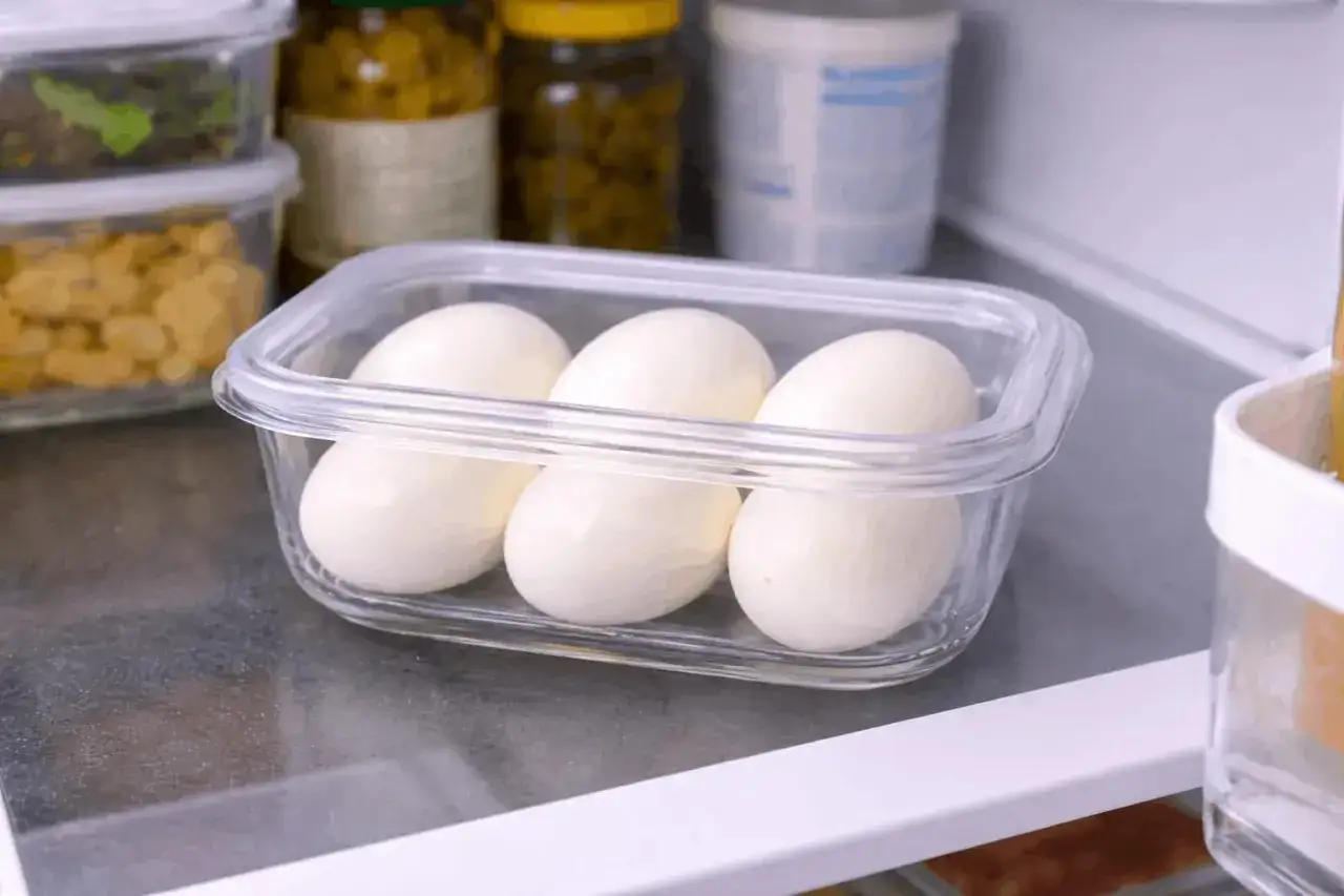 Trois &oelig;ufs durs dans une bo&icirc;te transparente pour une conservation optimale au r&eacute;frig&eacute;rateur.