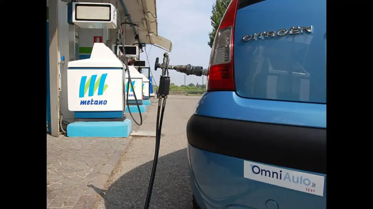 Rifornimento di metano per un'auto blu. La pompa di erogazione è collegata al veicolo, pronto per un pieno ecologico.