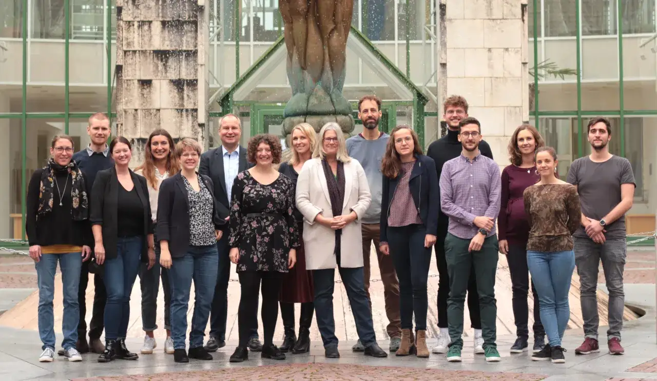Gruppe von Menschen vor einem Geb&auml;ude, die an der Salzburg Uni Psychologie arbeiten.
