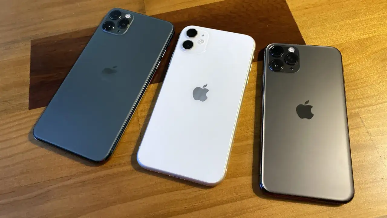 Trzy iPhone'y 11 w różnych kolorach: ciemnoszary, biały i grafitowy. Kiedy wyszedł iPhone 11, był to hit.