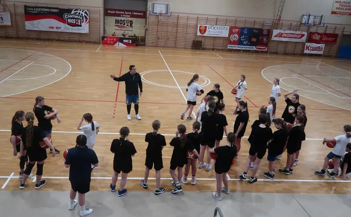 dzieci grające w koszykówkę na treningu w hali sportowej