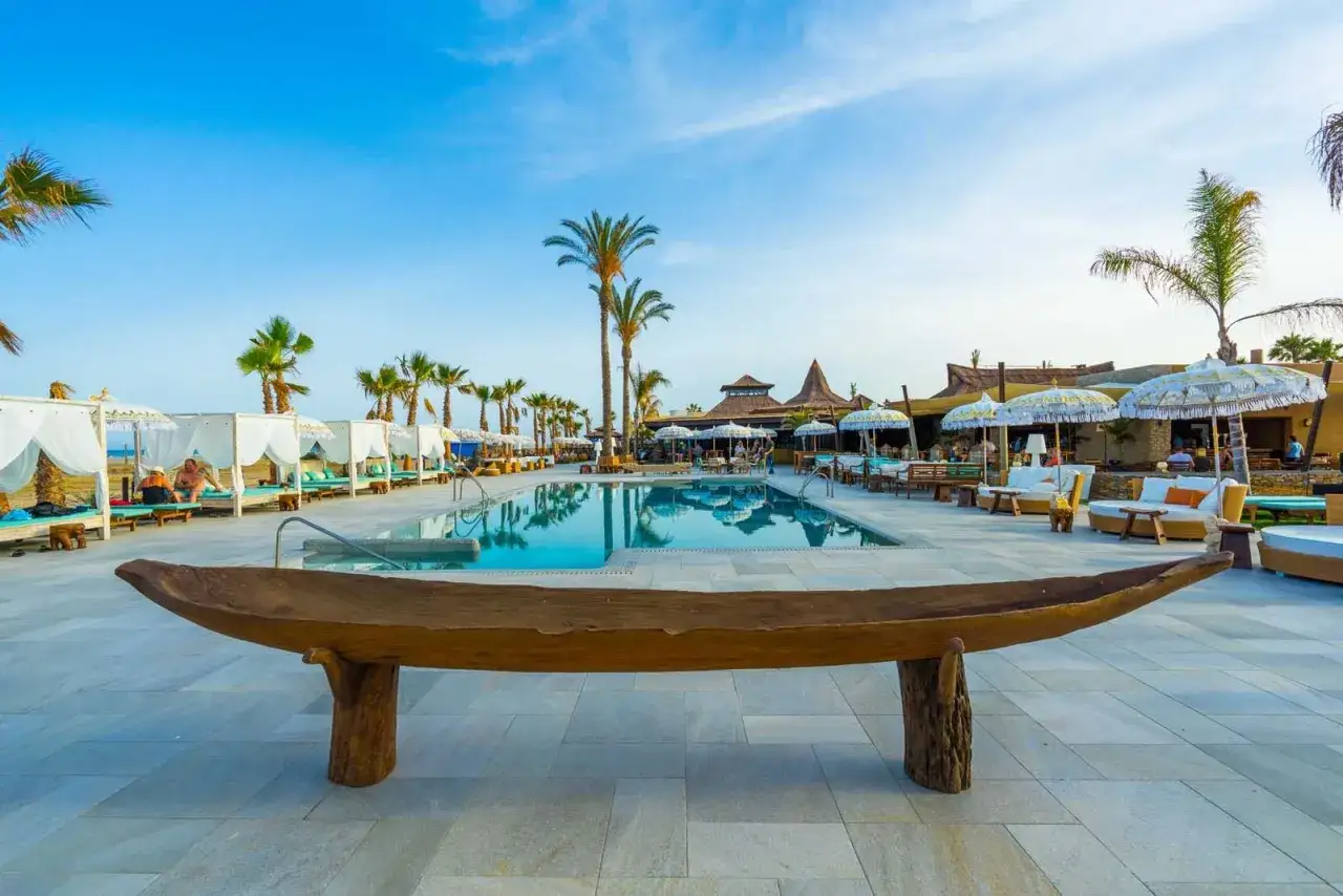 Disfruta de un día soleado en el beach club Mojácar, con piscina, palmeras y cómodas cabañas.