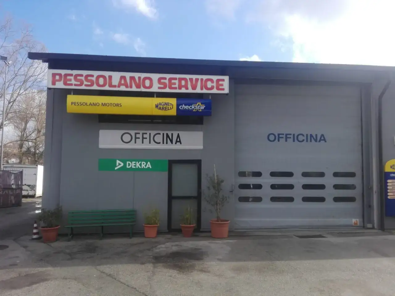 Officina PESSOLANO SERVICE, con insegne PESSOLANO MOTORS, Magneti Marelli, Checkstar e DEKRA. L'edificio sembra conforme all'articolo 80 del Codice della Strada per le officine.