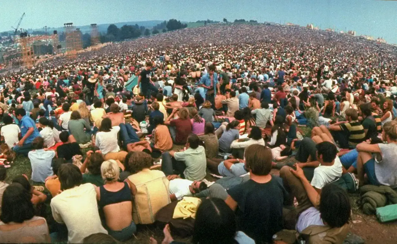 Tłum ludzi na wzgórzu, słynny festiwal Woodstock. To było legendarne wydarzenie, które zmieniło historię muzyki.