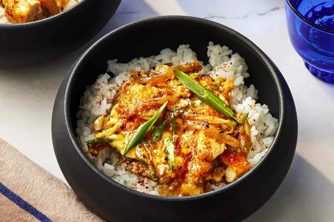 A delicious oyaku donburi recipe, featuring tender chicken and egg simmered in a savory sauce over fluffy white rice, garnished with green onions.