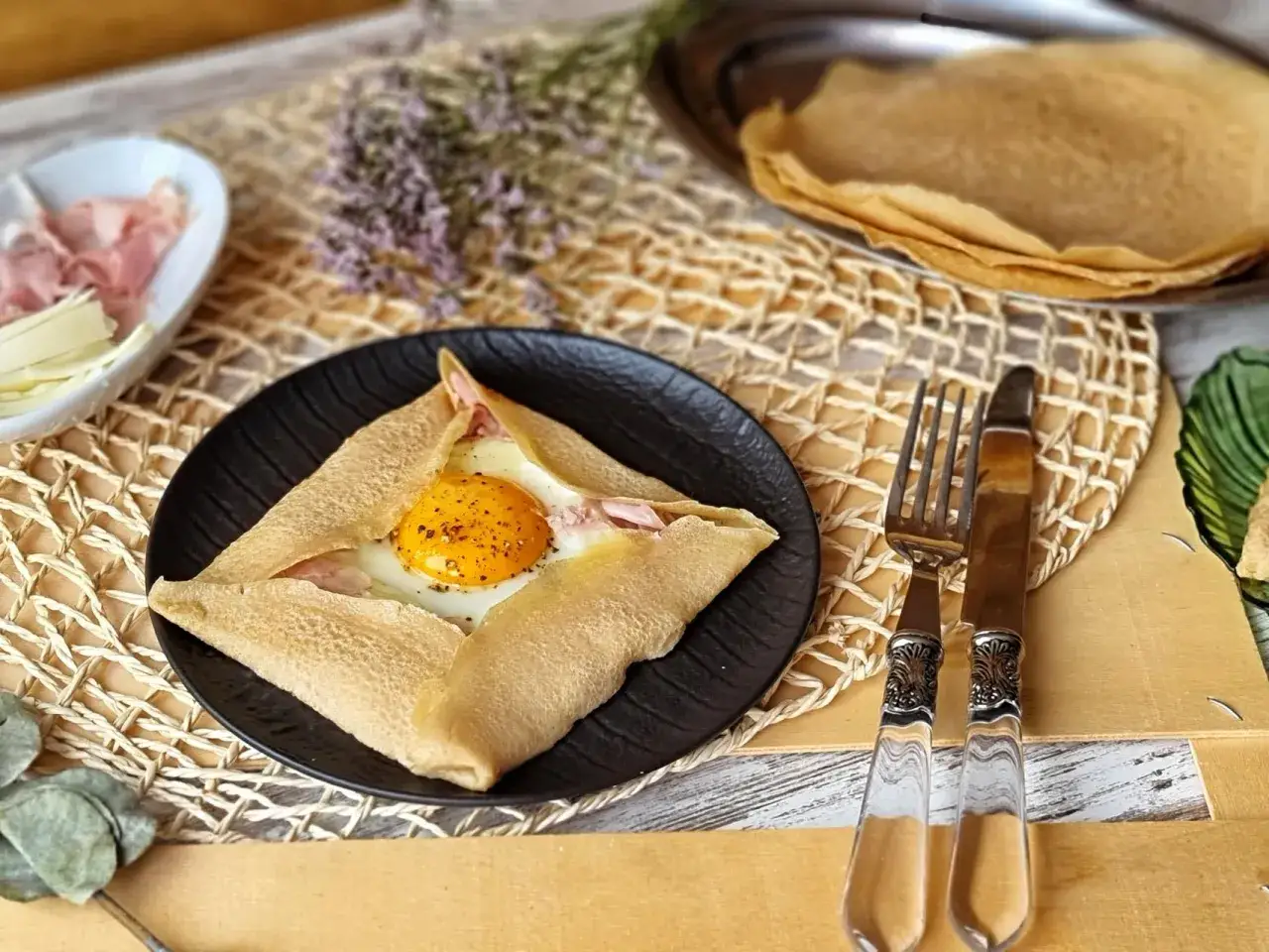 Un delicioso crepe en franc&eacute;s con huevo, jam&oacute;n y queso, listo para disfrutar.