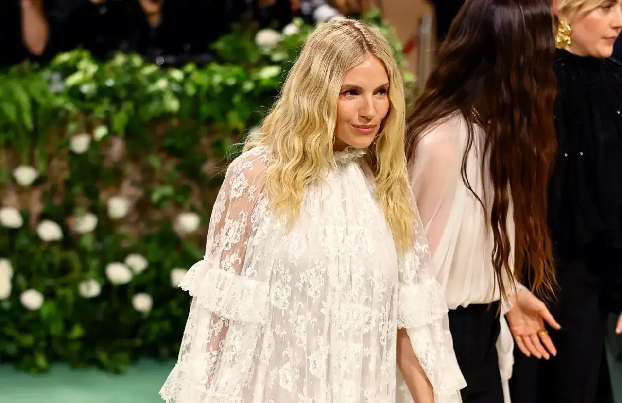 Une femme aux cheveux blonds ondul&eacute;s, v&ecirc;tue d'une robe blanche en dentelle, &eacute;voque un style boh&egrave;me chic, parfait pour un festival comme Coachella.