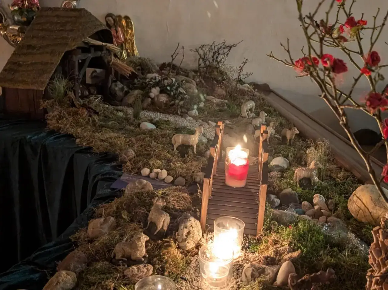 Krippe mit Lämmern und Kerzenlicht, die die Bedeutung von Weihnachten symbolisiert.