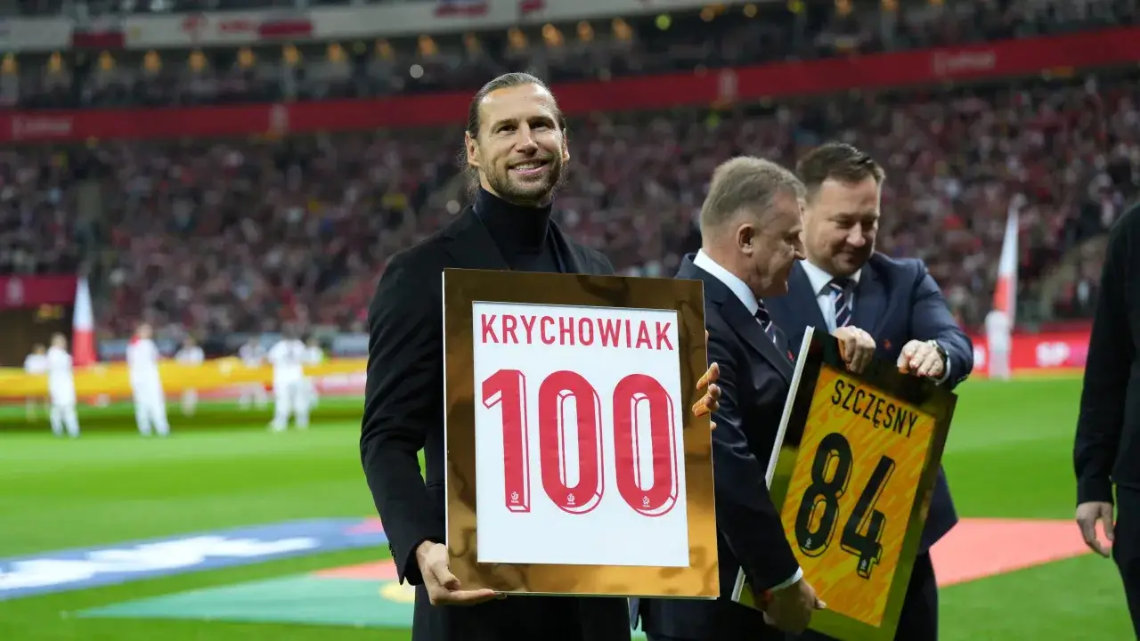 Grzegorz Krychowiak świętuje 100. mecz w reprezentacji Polski. Piłkarz z dumą prezentuje pamiątkową tabliczkę.