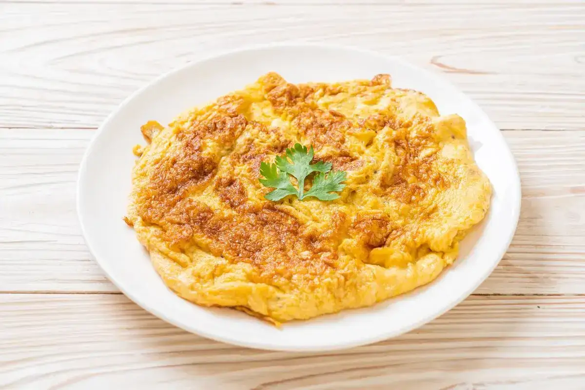 Frittata dorata e soffice, preparata in friggitrice ad aria, guarnita con prezzemolo fresco.