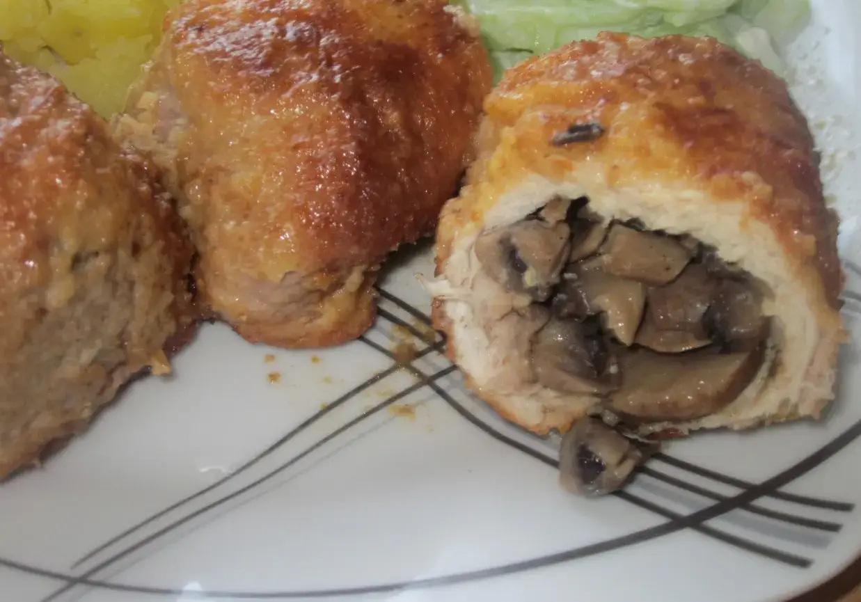 Kotlet husarski z pieczarkami, złocisty i apetyczny, podany z ziemniakami i surówką.