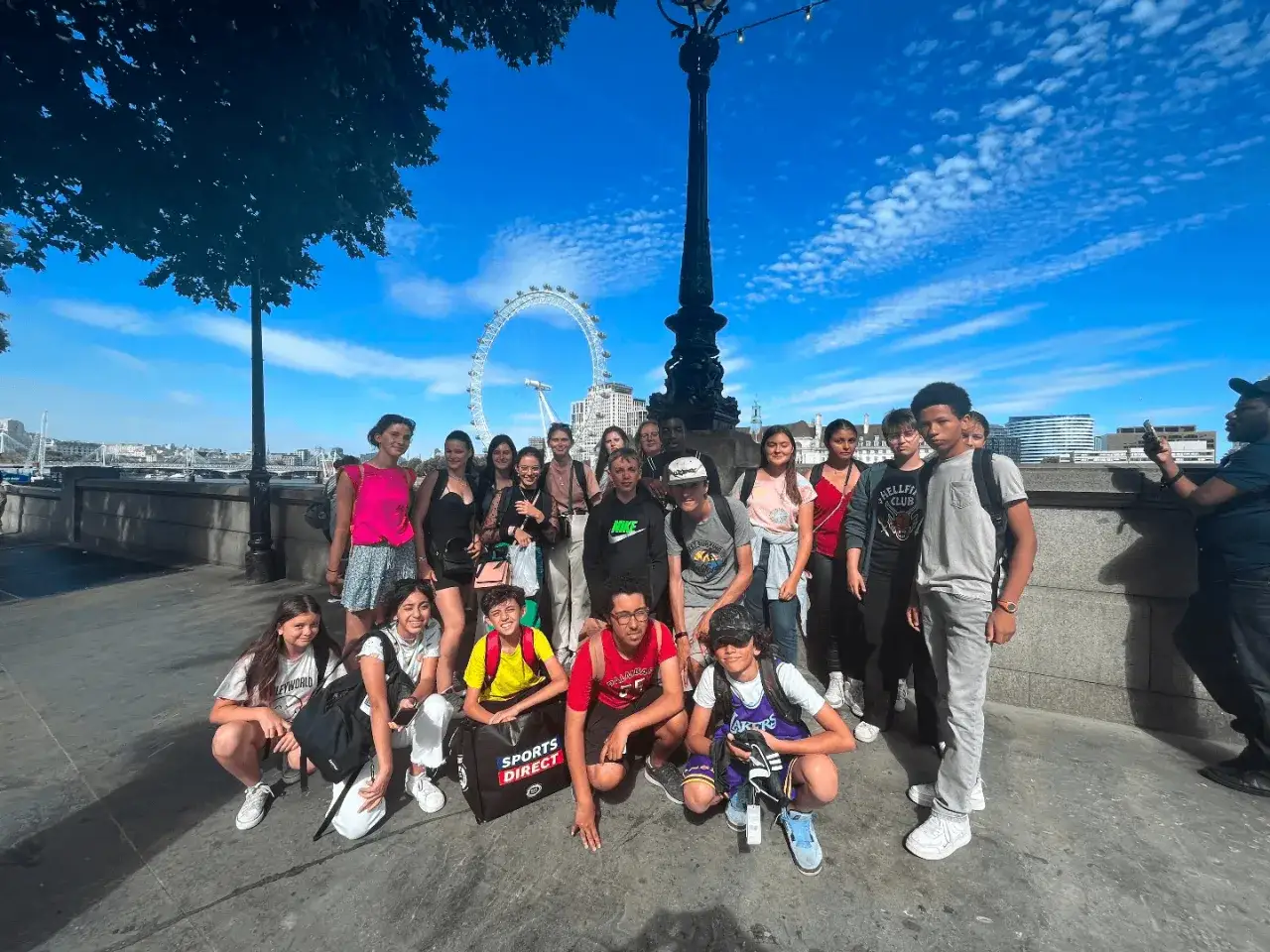 Un groupe d'adolescents profite de son sts sejour linguistique à Londres, avec le London Eye en arrière-plan.