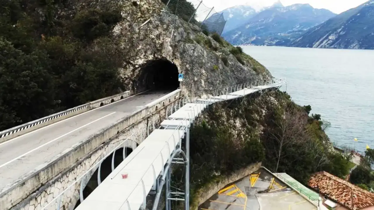 Spektakul&auml;rer **Radweg Gardasee** f&uuml;hrt entlang einer Felswand mit Tunnel und Br&uuml;cke &uuml;ber dem See.