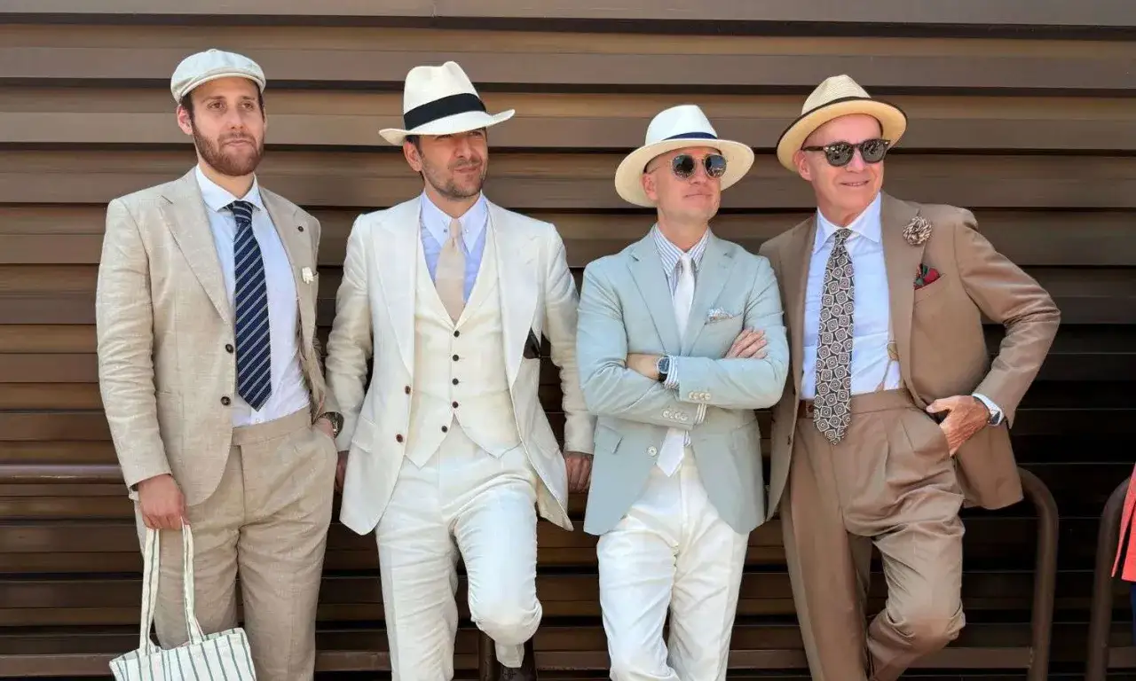 Quattro uomini eleganti in abiti chiari e cappelli, un look uomo d'altri tempi.