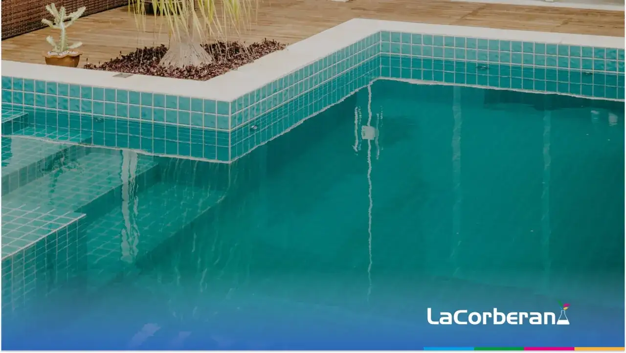 Agua de piscina blanquecina con escalones de acceso y vegetación tropical.