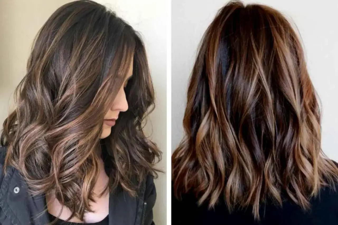 Chevelure brune avec des reflets subtils, un magnifique french balayage qui illumine la chevelure ondulée.