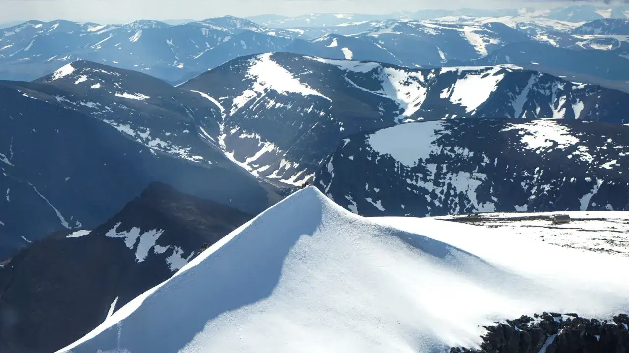 Imponerande kebnekaise utsikt med snöklädda berg och en liten stuga i fjärran.