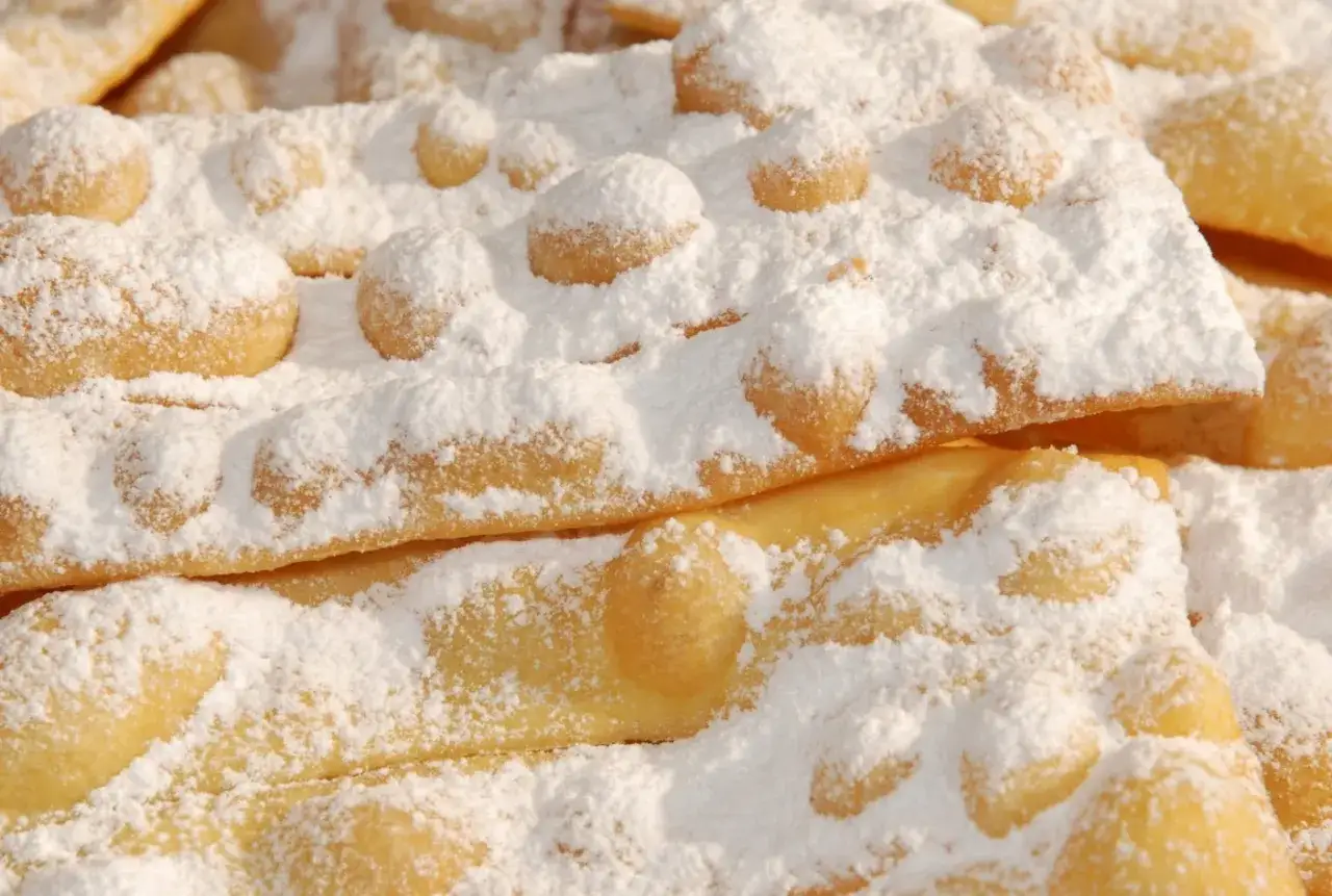 Bugie ricetta originale: dolcetti fritti cosparsi di zucchero a velo, croccanti e leggeri, perfetti per ogni occasione.