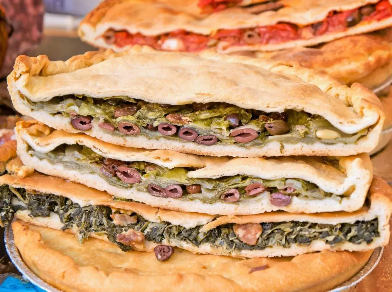 Torta salata con verdure e olive, un classico da provare a Gaeta. Cosa mangiare per un sapore autentico.