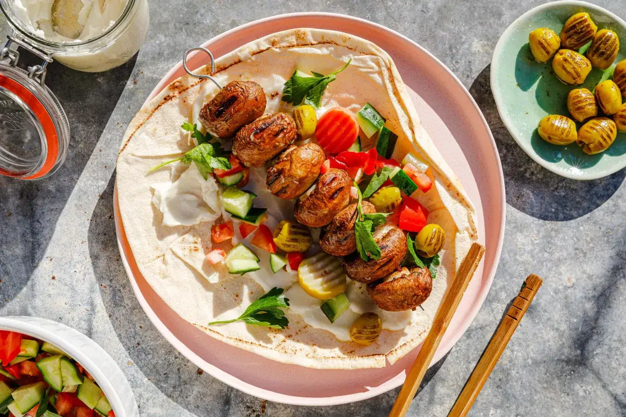 Gegrillte Champignon-Spie&szlig;e auf Fladenbrot mit frischem Gem&uuml;se und Dip. Perfekt f&uuml;r vegane Grillrezepte!
