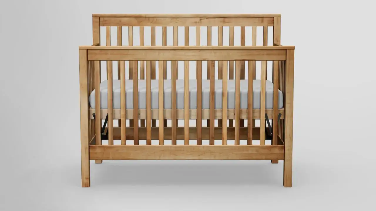 A wooden crib with a white mattress, showcasing what is the safest crib for a baby.