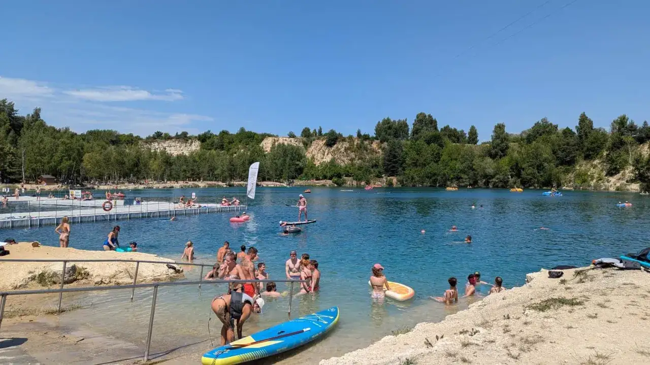 Ludzie kąpią się i pływają na deskach SUP w słoneczny dzień nad zalewem Balaton Trzebinia.