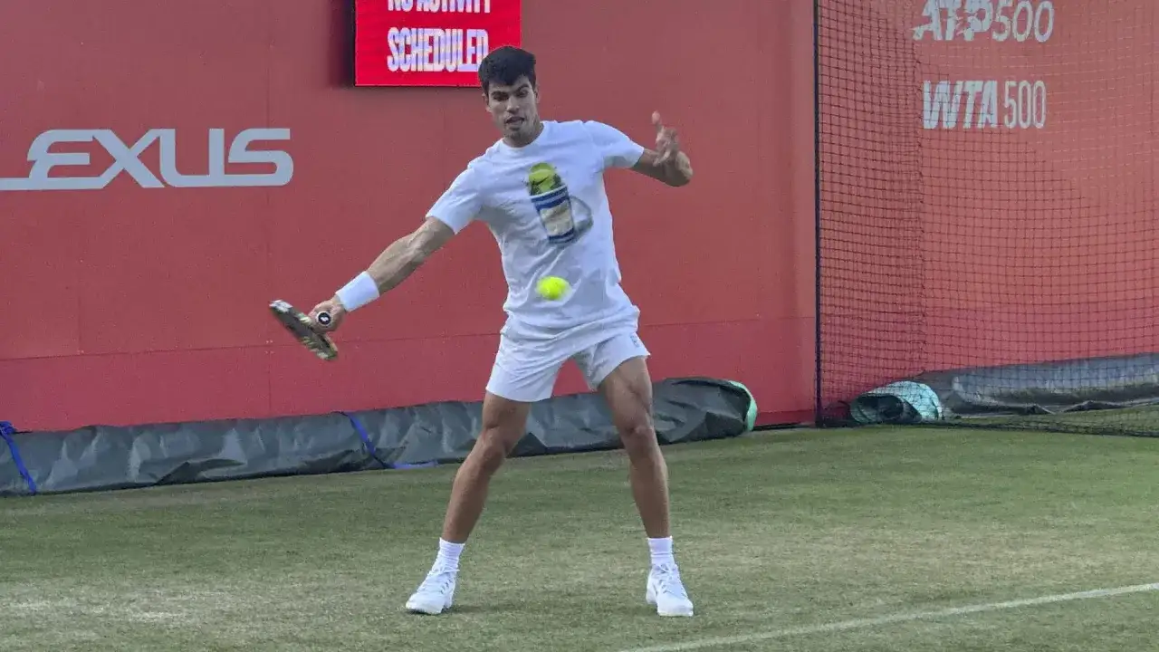 Carlos Alcaraz se prepara para su pr&oacute;ximo partido, golpeando la pelota en la cancha.