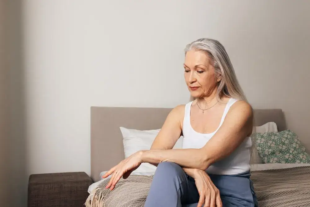 Kobieta w średnim wieku zastanawiająca się nad objawami ciąży lub menopauzy, symboliczne porównanie objawów