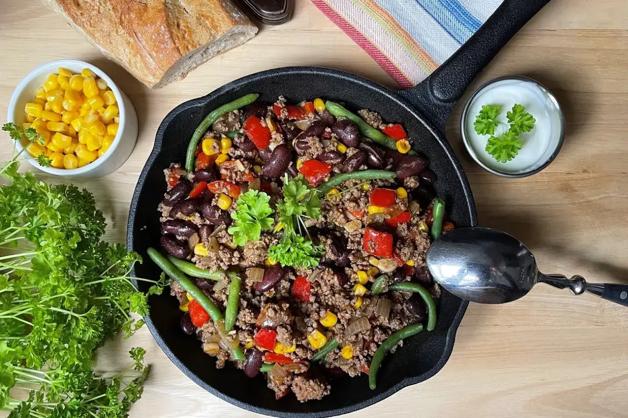 Herzhafte Hackfleischpfanne mit Bohnen, Mais und Paprika &ndash; ein Beweis f&uuml;r schnelle Hackfleisch Rezepte. Dazu frische Petersilie und ein Klecks Sour Cream.