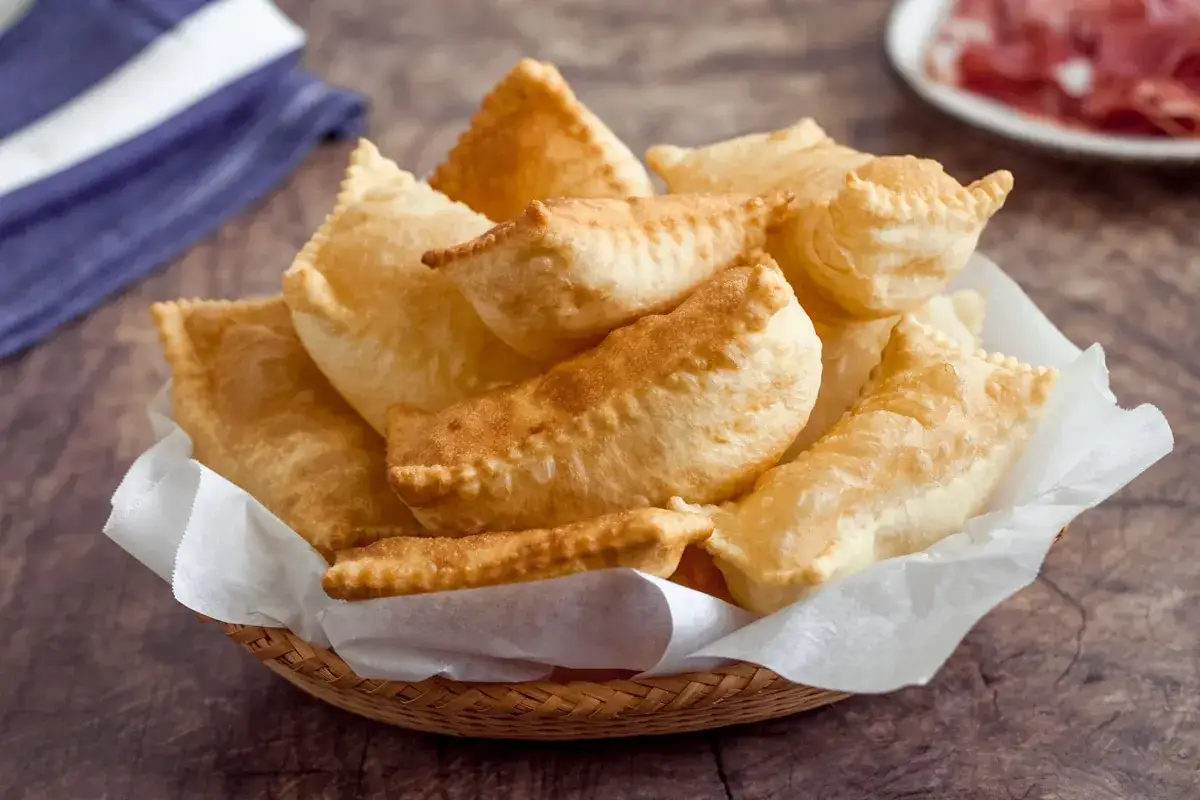 Cesto di gnocco fritto modenese dorato e croccante, pronto per essere gustato con salumi.