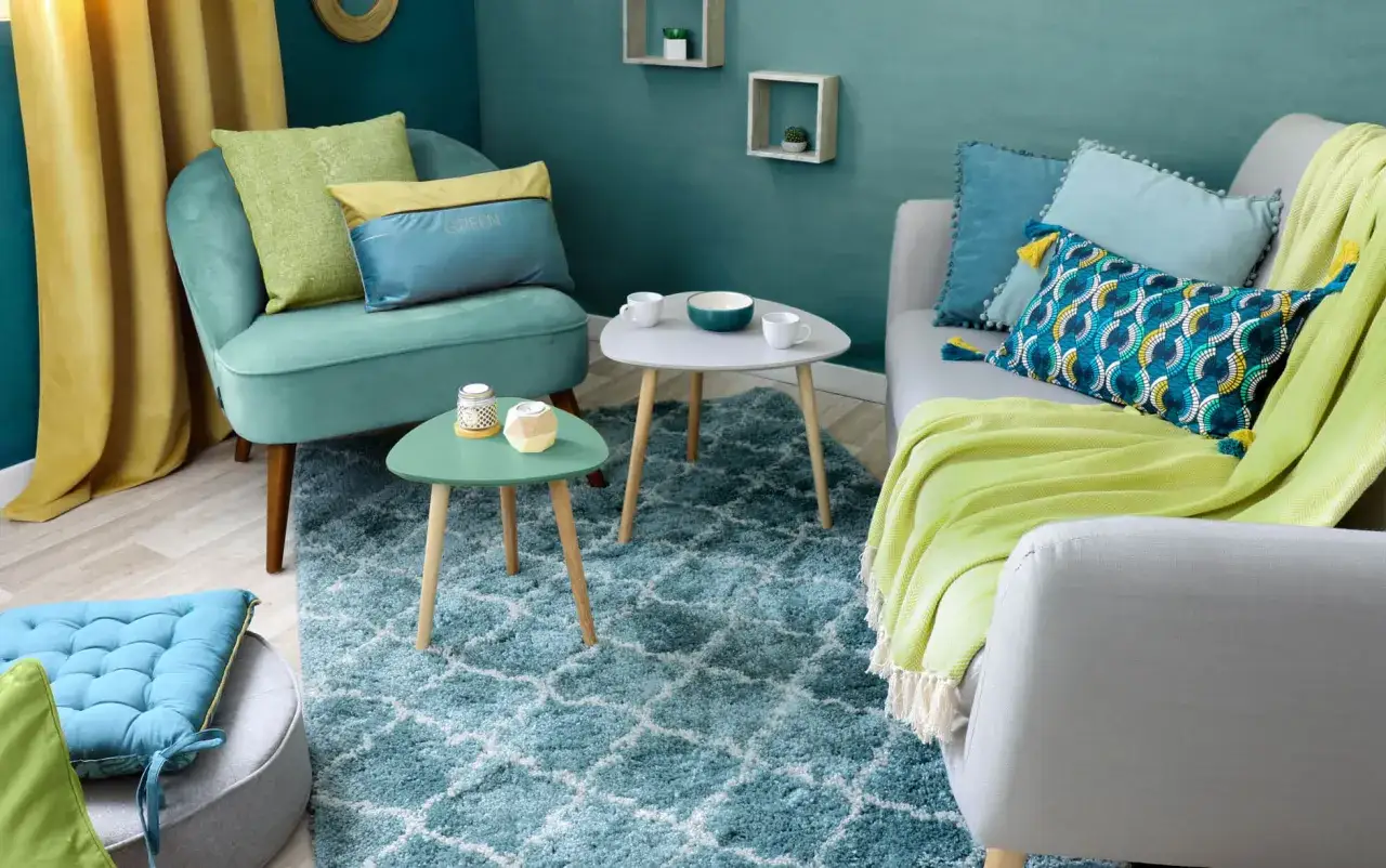 Salon aux teintes aquatiques et végétales. Une association de couleur peinture audacieuse, du turquoise au vert pomme, rehaussée de touches dorées.