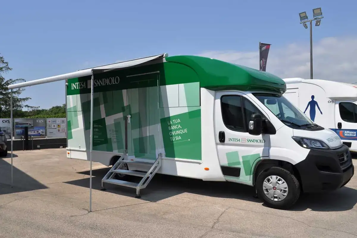 Veicoli atipici: un furgone Intesa Sanpaolo con tenda estesa, pronto a offrire servizi bancari ovunque.