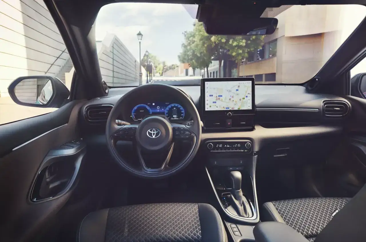 Interi&ouml;rvy av en Toyota Yaris Hybrid under en testk&ouml;rning. Ratt, instrumentpanel med GPS och v&auml;xell&aring;da syns tydligt.