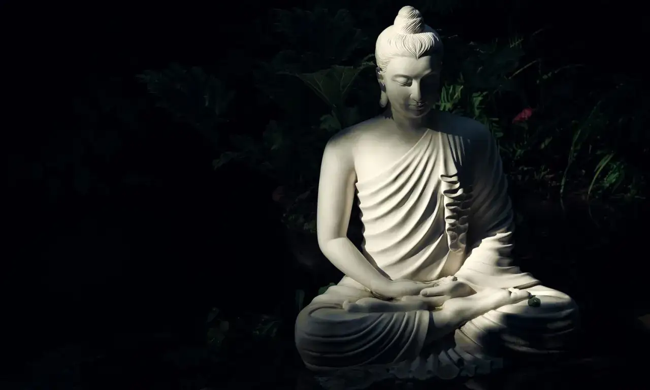 Estatua de Buda en meditación, bañada por la luz, evoca la serenidad del mundo espiritual.