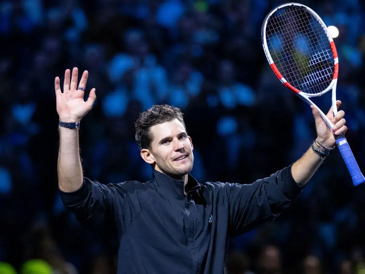 Dominic Thiem wita się z publicznością, trzymając rakietę tenisową.